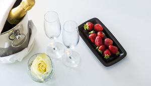 a table with wine glasses and a plate of strawberries at Hotel Excelsior - Liburnia in Lovran