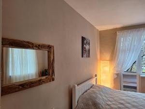 a bedroom with a mirror and a bed and a window at Cozy apartment in the heart of Sofia in Sofia