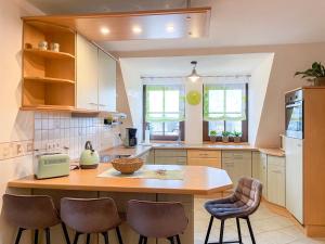 a kitchen with a wooden table and chairs at FeWoMaurer WG1 Dachgeschoss in Altendorf