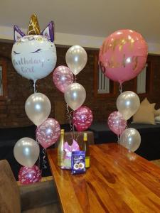 Ein Haufen rosa und weißer Ballons auf dem Tisch in der Unterkunft Infinity Partypadsliverpool Hen And Stag Welcome in Liverpool