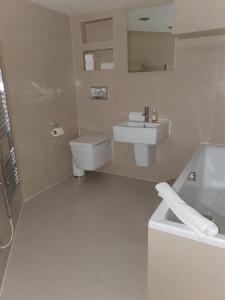 ein weißes Bad mit einem Waschbecken und einem WC in der Unterkunft Infinity Partypadsliverpool Hen And Stag Welcome in Liverpool