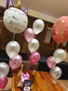 a bunch of pink and white balloons and champagne bottles at Infinity Partypadsliverpool Hen And Stag Welcome in Liverpool