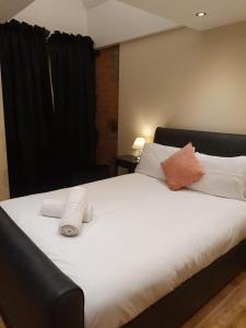 a bedroom with a large white bed with towels on it at Infinity Partypadsliverpool Hen And Stag Welcome in Liverpool