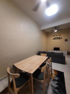 a dining room with a wooden table and chairs at D'homestay Parit Buntar in Parit Buntar