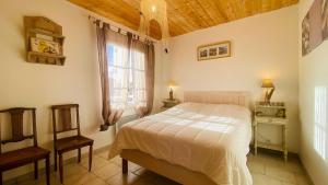 a bedroom with a bed and a chair and a window at Charmante Villa avec étage proche plage in La Couarde-sur-Mer