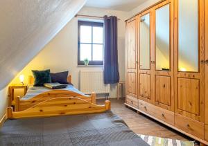 1 dormitorio con cama de madera y ventana en FeWoMaurer WG1 Dachgeschoss, en Altendorf