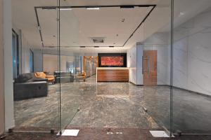 a lobby with a glass wall and a couch at CR RIVERA in Madurai