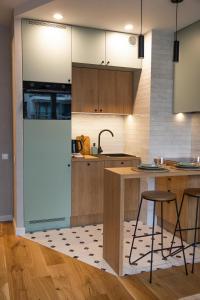 a kitchen with wooden cabinets and a counter with stools at Jezyce Good Place Free Parking in Poznań