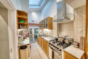 a large kitchen with a stove and a sink at Luxury Terraced Victorian House in London