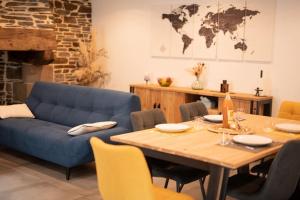a living room with a blue couch and a table at Gîte Manoir de Kerlez Plain-pied in Briec