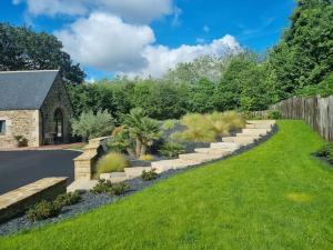 a garden with a stone path and plants at Gîte Manoir de Kerlez Plain-pied in Briec