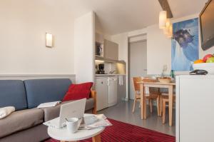 a living room with a couch and a table with a laptop at Résidence Pierre & Vacances Antarès in Avoriaz