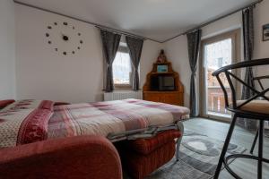 1 dormitorio con 1 cama y reloj en la pared en Vision Apartment - Livigno, en Livigno