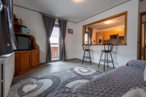 1 dormitorio con 1 cama y TV y cocina en Vision Apartment - Livigno, en Livigno