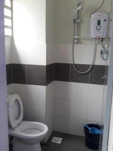 een kleine badkamer met een toilet en een douche bij Camlodge Apartments in Tanah Rata