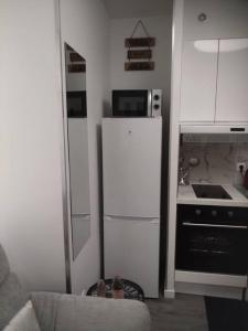 Il comprend une petite cuisine équipée d'un réfrigérateur blanc et d'une cuisinière. dans l'établissement Le Petit Suc du Puy En Velay , Hyper centre ,calme ,Parking proche, au Puy-en-Velay