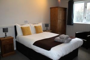 a bedroom with a large bed with towels on it at Dog and Partridge Inn in Calne