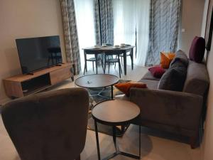 a living room with a couch and a tv and tables at Prime Homes Gambia Luxury Apartment in Sere Kunda