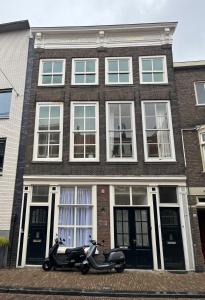 Artistic apartment, City Centre Dordrecht في دوردريشت: سكوتر متوقف أمام مبنى من الطوب