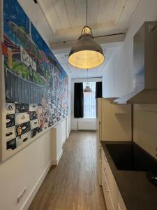 Artistic apartment, City Centre Dordrecht في دوردريشت: مطبخ به لوحة كبيرة على الحائط