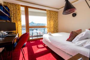 a hotel room with a bed and a desk and a window at La Residence Du Vieux Port in Marseille