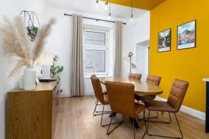 a dining room with a wooden table and chairs at The Stylish 3-Bedroom Maisonette Retreat in Stirling