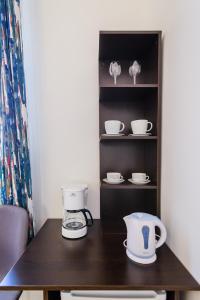 a counter with a coffee maker and dishes on a shelf at Summertime Apartments in Zadar