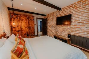 a brick walled bedroom with a bed and a tv at The Owl's Nest 2 in Velingrad +12 photos