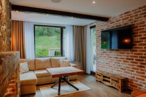 a living room with a couch and a brick wall at The Owl's Nest 2 in Velingrad