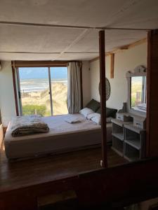 a bedroom with a bed with a view of the ocean at Solar Valizas in Barra de Valizas