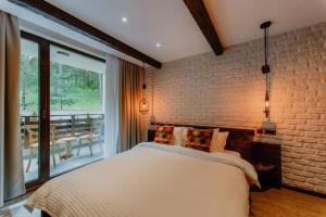 ein Schlafzimmer mit einem weißen Bett und einer Ziegelwand in der Unterkunft The Owl's Nest 2 in Welingrad