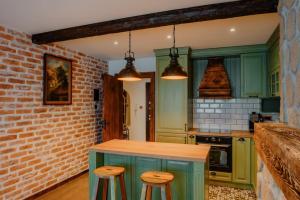 a kitchen with green cabinets and a brick wall at The Owl's Nest 2 in Velingrad