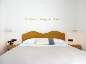 a bedroom with a large bed with a quote on the wall at Tramas Hotel & Spa in Olbia