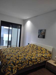 a bedroom with a bed and a window at Duplex One Hill Ville Verte M in Casablanca