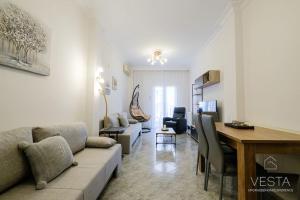 sala de estar con sofá, mesa y escritorio en Origami Urban Residence, Vesta Philoxenia, en Tesalónica