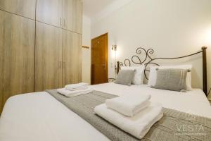 Un dormitorio con una cama blanca con toallas. en Origami Urban Residence, Vesta Philoxenia, en Tesalónica