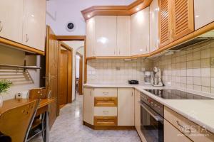una cocina con electrodomésticos blancos y armarios de madera en Origami Urban Residence, Vesta Philoxenia, en Tesalónica
