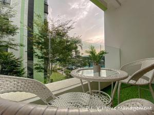 a patio with a table and chairs on a balcony at Crystal Cozy Suite PoolView Netflix Waterpark@ Ipoh Station 18 in Ipoh