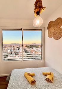 a bedroom with two towels on a bed with a window at VistaBonitaHome in Alicante