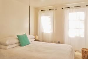 a bedroom with a bed with a green pillow on it at Unique Georgian Garden Flat in Central Margate in Margate