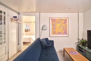 a living room with a blue couch and a tv at Unique Georgian Garden Flat in Central Margate in Margate