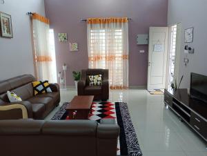 a living room with a couch and a tv at Mysa Homestay in Kampong Batu Dua