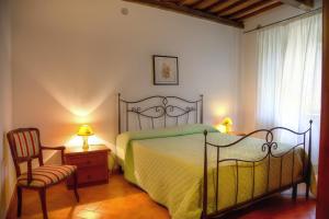 1 dormitorio con 1 cama, 1 silla y 2 lámparas en Agriturismo L'Elce en Bolsena