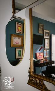 um espelho numa parede com uma secretária e quadros emoldurados em MR SQUARE apartment em Catânia