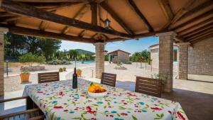 a table with a bowl of fruit on a patio at Villa Tovarovica in Primošten