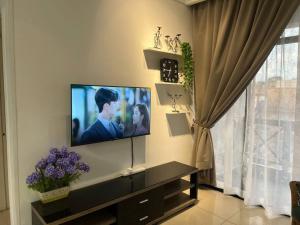 a living room with a flat screen tv on a wall at Urban Oasis Retreat in Melaka