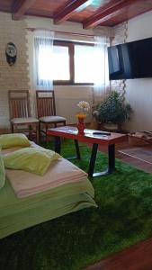 Cette chambre comprend une table et un tapis vert. dans l'établissement Family Home, à Cheia