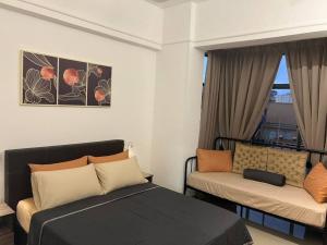 a bedroom with a bed and a couch and a window at Urban Oasis Retreat in Melaka