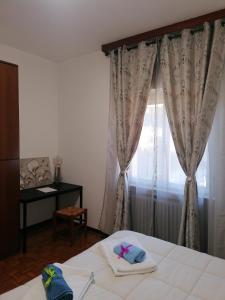 a bedroom with a bed and a window with curtains at Casa Vacanze Mari, Paratico in Paratico