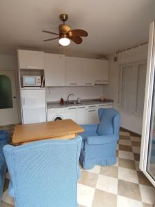 cocina con sillas azules, mesa y ventilador de techo en Apartamento Urba Ruta del Veleta, en Cenes de la Vega